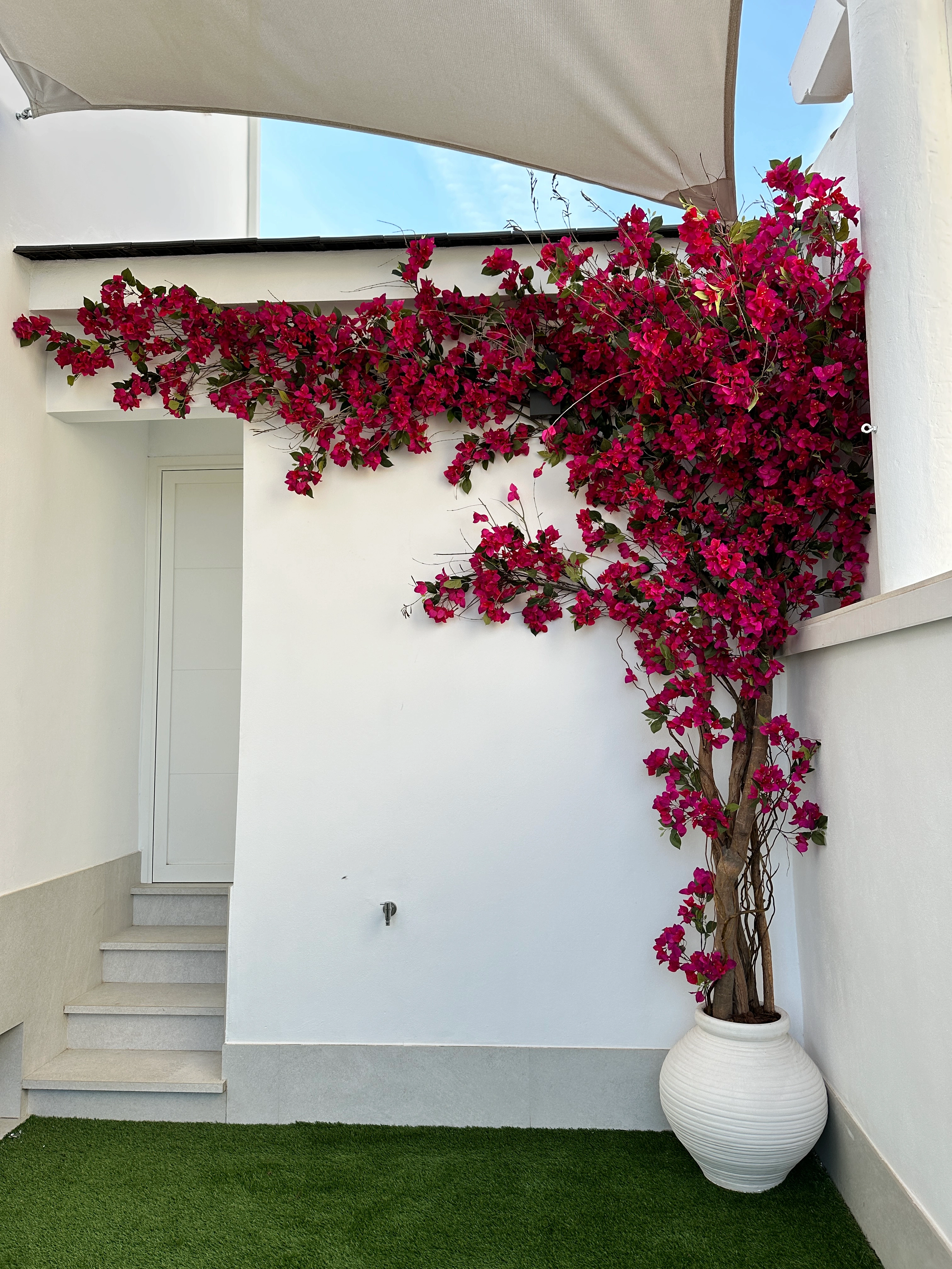 Decoración con buganvillas artificiales en patio blanco