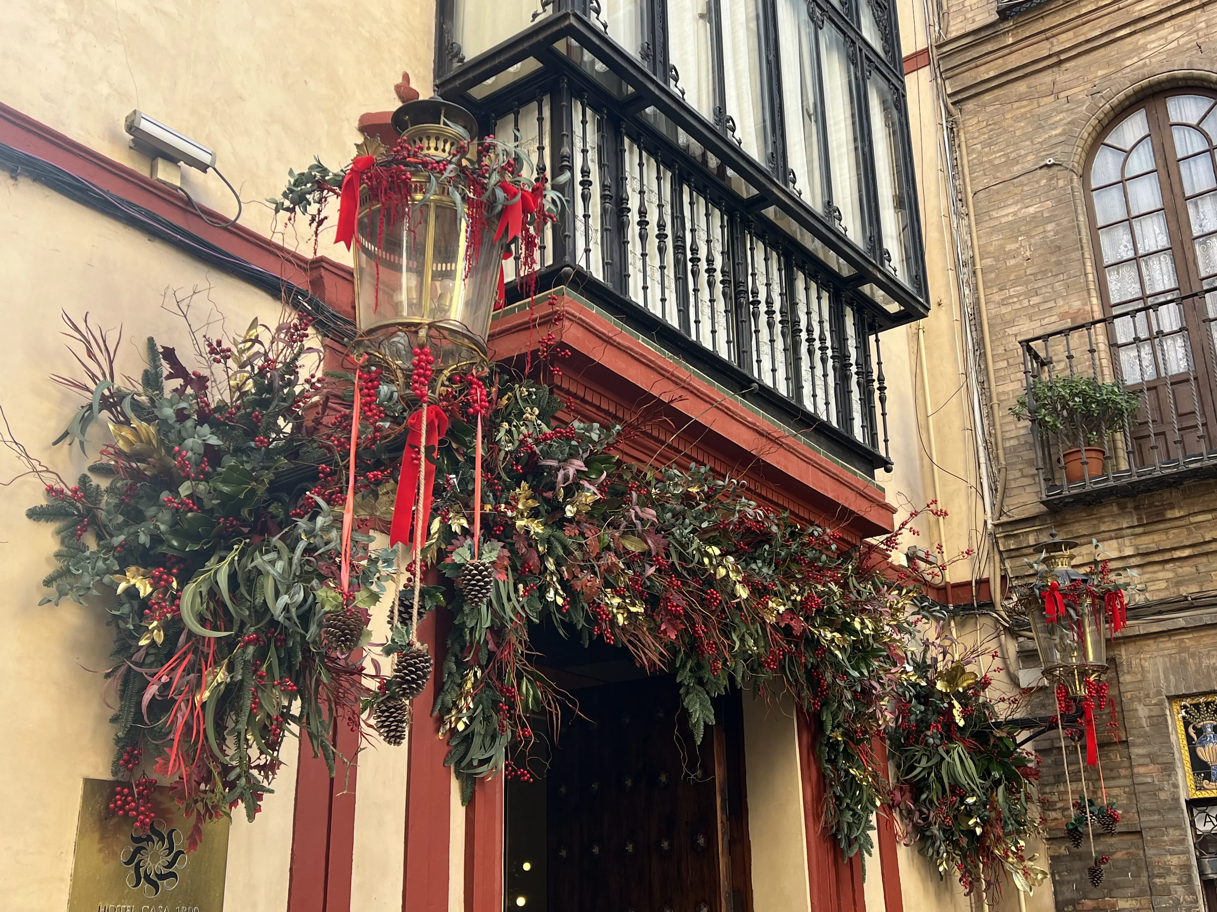 Decoración navideña exterior en Hotel Casa 1800 con vegetación y cintas rojas